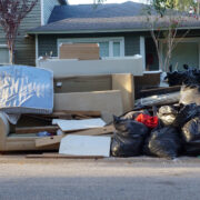 pile of old furniture and junk in front of a house