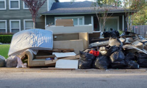 pile of old furniture and junk in front of a house